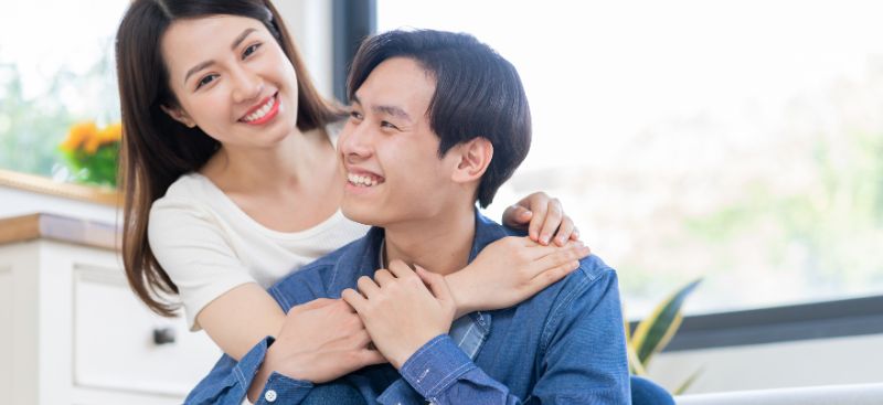 A smiling Chinese couple in Hong Kong considering a BNO visa mortgage in the UK.